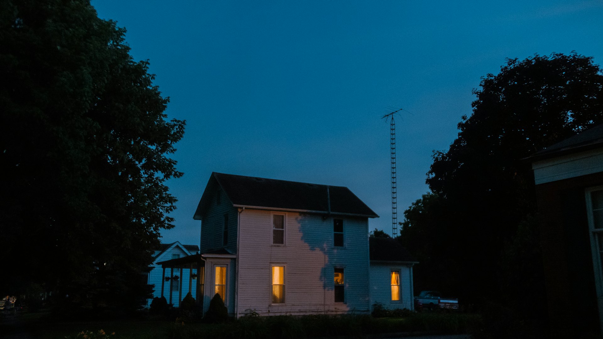 A New Jersey home at dusk with its windows lit